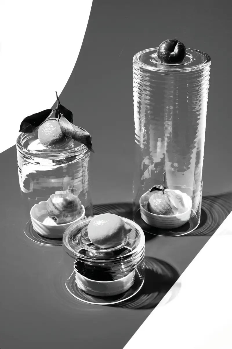 Schwarz-Weiß-Fotografie von drei Gläsern mit runden Früchten