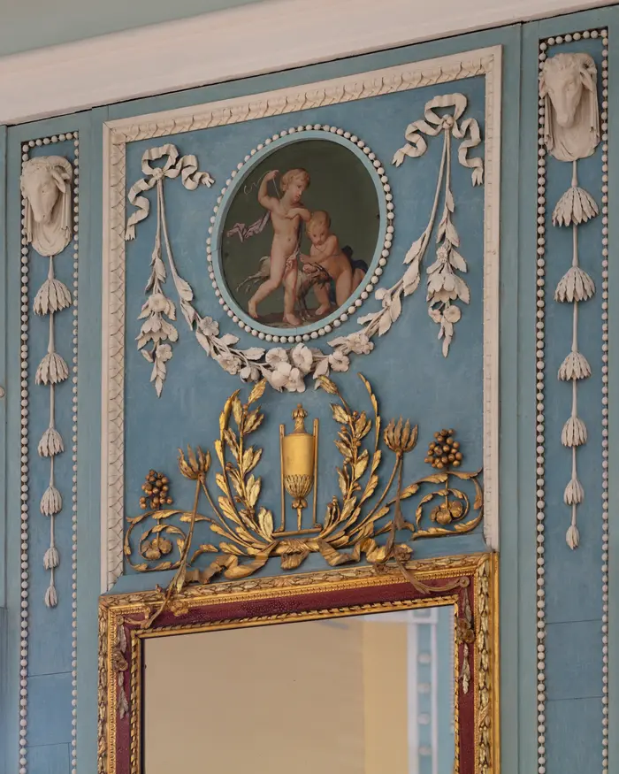 Schwungvolle goldene und weiße Wandmalereien und Stuckverzierungen 