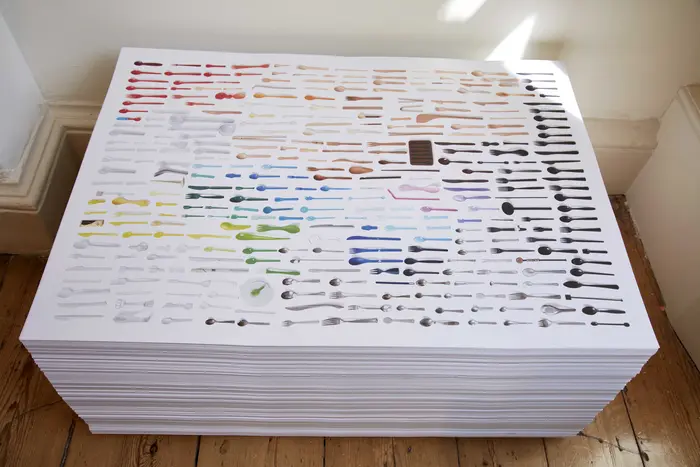 Stapel mehrerer mit bunten Löffeln bedruckter Papiere