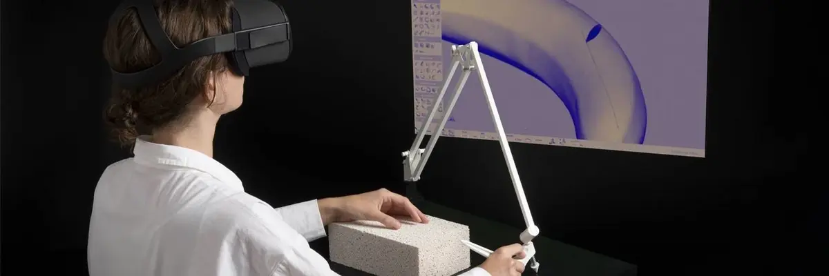 Mensch mit VR-Brille steht vor Bildschirm mit Schneidegerät