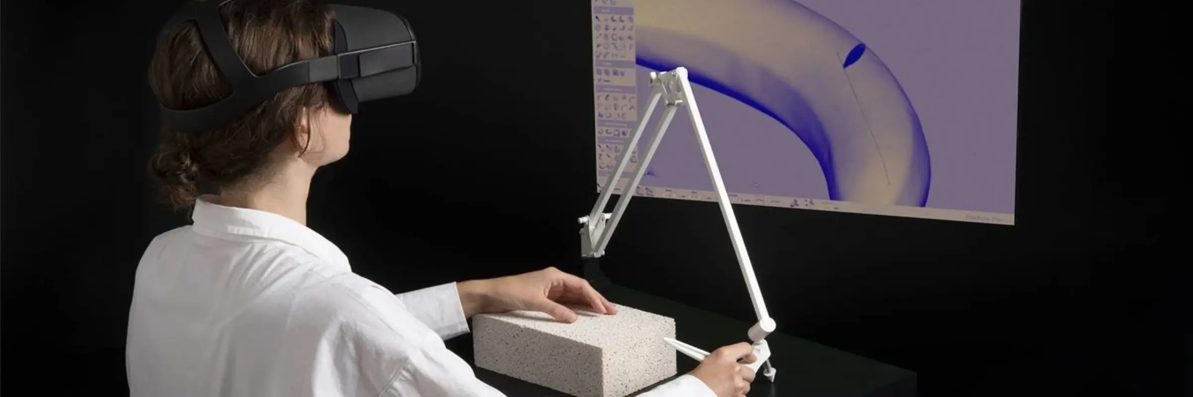 Mensch mit VR-Brille steht vor Bildschirm mit Schneidegerät
