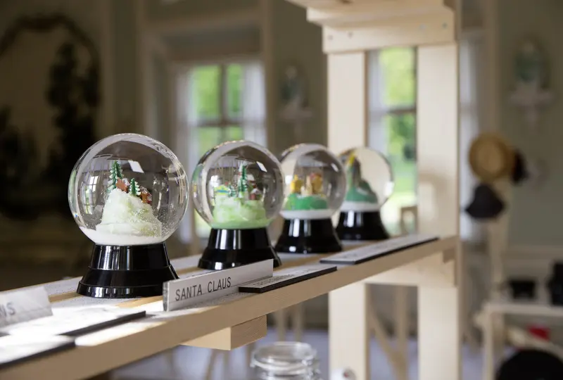 Foto mit vier Schneekugeln auf einem Holzgerüst