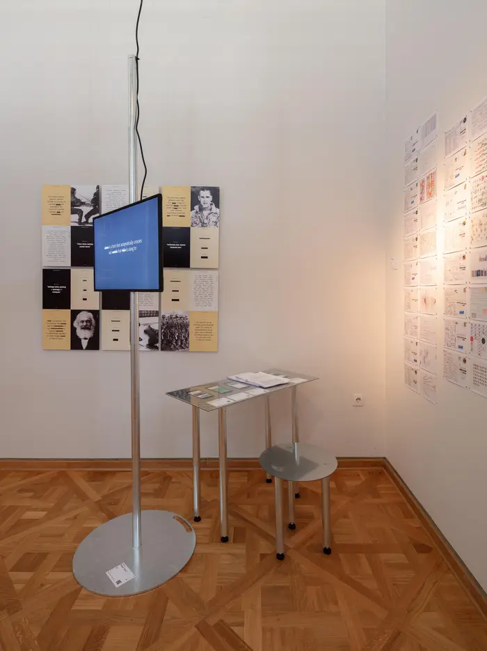 Ausstellungsansicht eines Monitors und verschiedener Informationstafeln