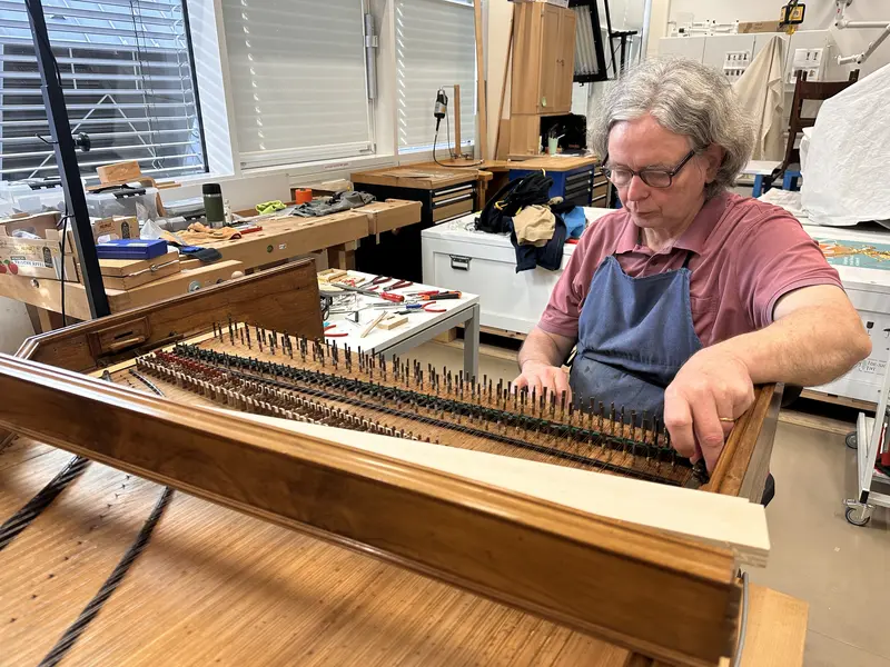Restaurator Roland Hentzschel arbeitet am Cembalo von Johann Daniel Silbermann