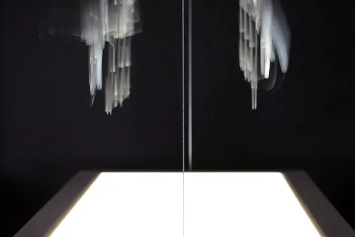 Schwarzes Bild mit zwei weißen Schatten