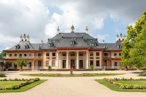 Vor dem Bergpalais eine Gartenanlage mit Teich und Wasserfontäne