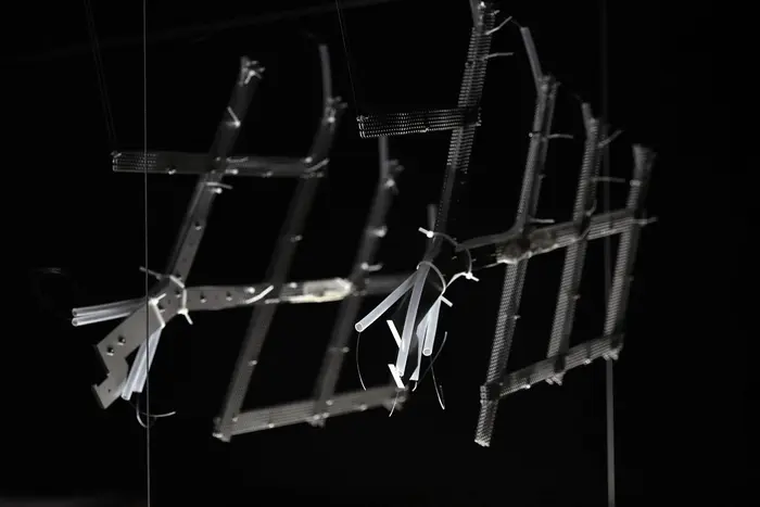 Eckiges Metallgerüst vor einem dunklen Hintergrund