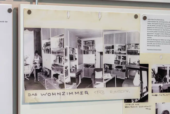 Informationstafel mit Fotografie eines Wohnzimmers und Informationstext