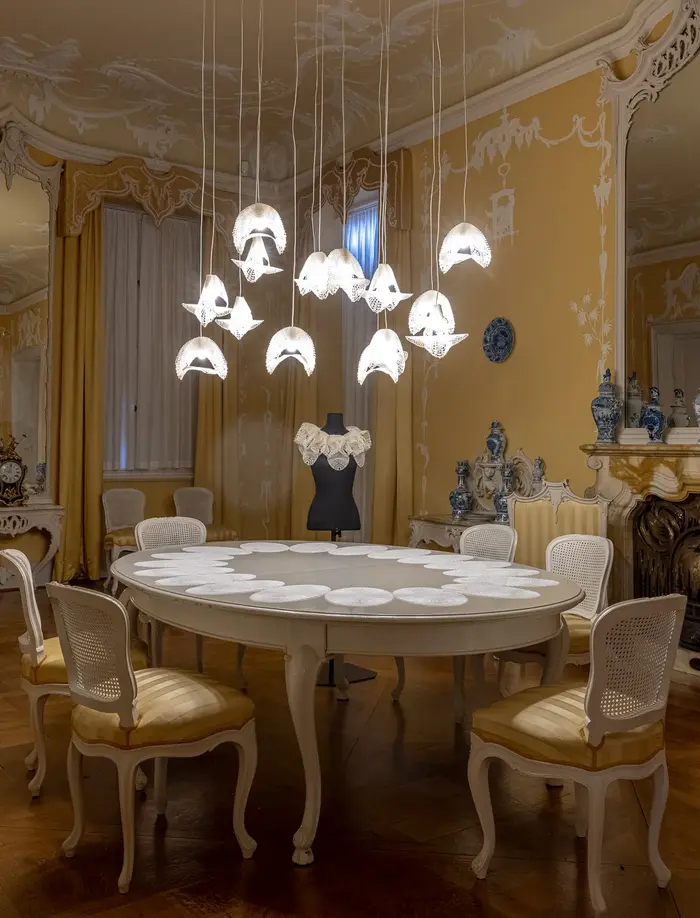 Ansicht eines historischen Saals mit Tisch und Stühlen