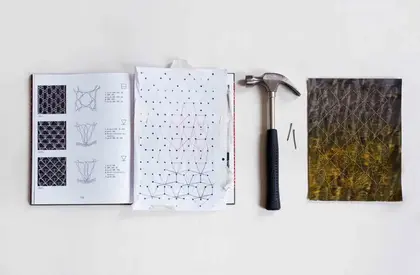 aufgeschlagenes Buch neben einem Hammer