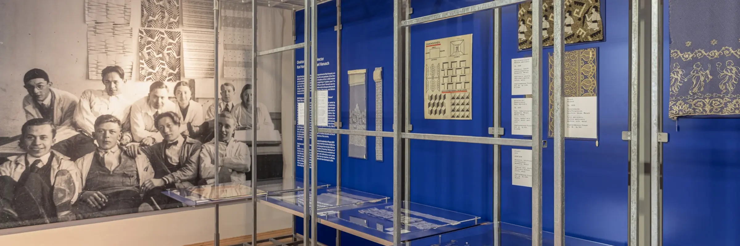 Ausstellungsansicht verschiedener Präsentationsflächen und einer großen Schwarz-Weiß-Fotografie