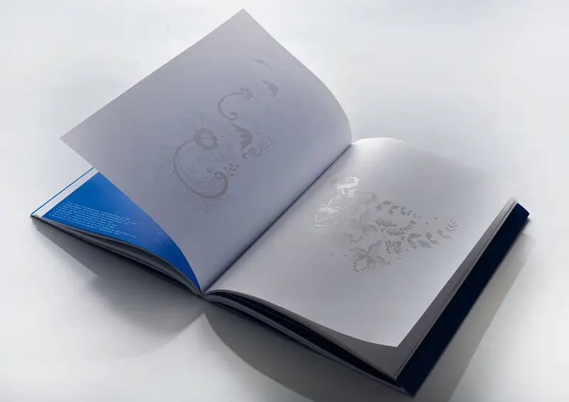 Aufgeschlagenes Buch mit filigranen, geschwungenen Blumenmustern 