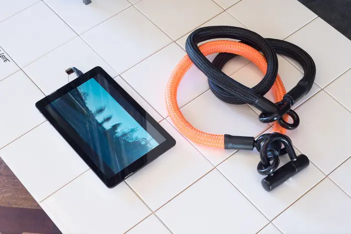 ein Tablet, daneben zwei dicke Seile mit Ösen an Enden und Schloss