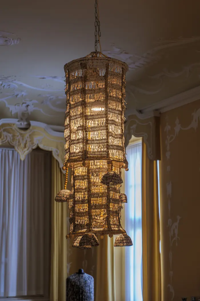 Deckenlampe mit aus beigen Fäden gewebtem Schirm