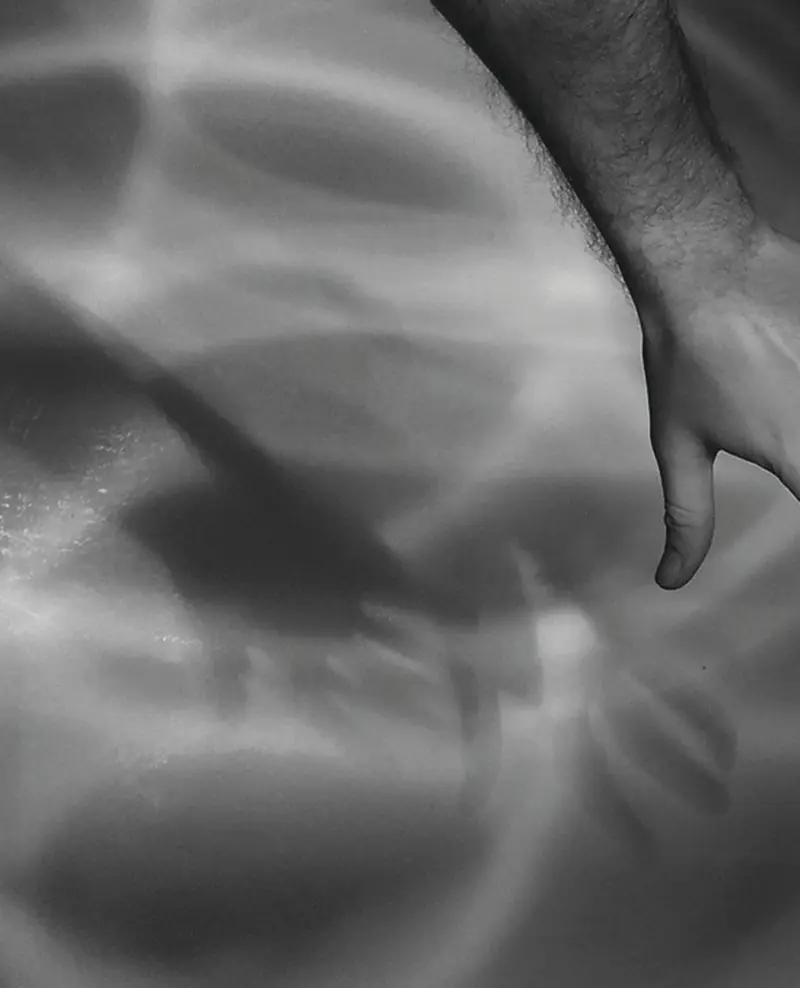 Schwaz-Weiß-Fotografie einer Hand über Wasser