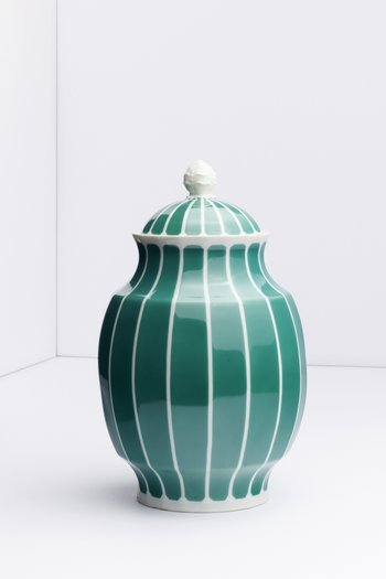Eine grüne Vase mit weißen Streifen und Deckel