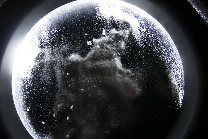 Glitzernde Partikel unter einem runden Glas