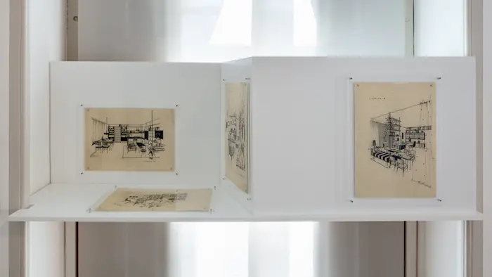 Ausstellungsansicht verschiedener ausgehängter Skizzen von Innenräumen